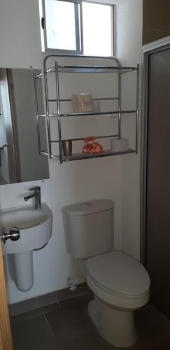 y baño con aseo blanco y lavamanos. en Bellohorizonte Apartamento SMR, en Santa Marta