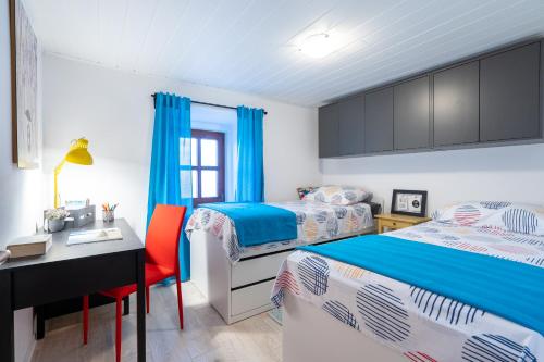 a bedroom with two beds and a desk and a table at Holiday House Nova in Stara Baška