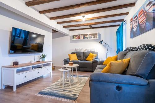 a living room with a couch and a tv at Holiday House Nova in Stara Baška