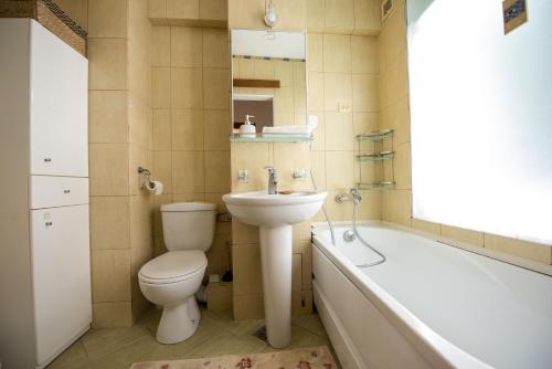 a bathroom with a toilet and a sink and a bath tub at Cozy Apartment in Suceava in Suceava
