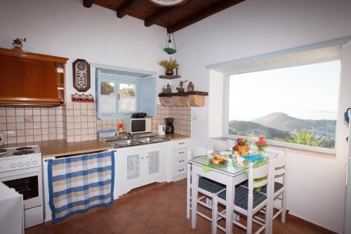 a kitchen with a table and a sink and a window at Patmos Chora traditional villa Genadio in Patmos