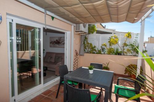 patio con mesa y sillas en el balcón en Penthouse with terrace in Marbella- Costa del Sol, en Marbella