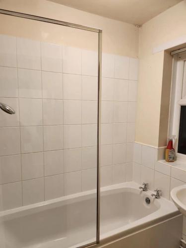 a bathroom with a bath tub and a sink at Spacious Single bed Manchester in Middleton