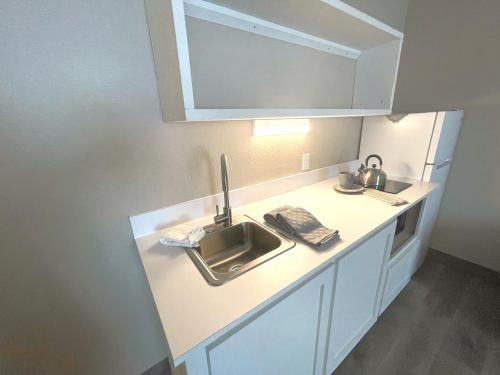 eine Küchentheke mit einer Spüle und einer Mikrowelle in der Unterkunft FairBridge Extended Stay, a Kitchenette Hotel in Idaho Falls