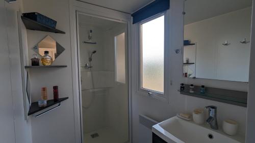 a bathroom with a shower and a sink and a mirror at Mobilhome Eleganzia 713 Bonne Anse Plage in Les Mathes