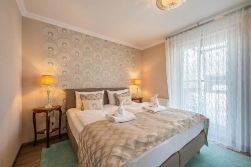 1 dormitorio con 1 cama grande y toallas. en Appartement Am Park der Sinne & Am See, en Binz