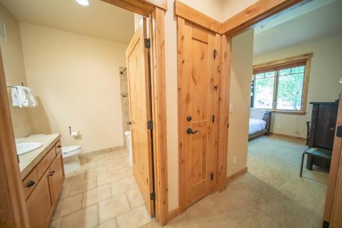 ein Badezimmer mit einer Holztür und einem Waschbecken in der Unterkunft Settlers Creek 6514 in Keystone
