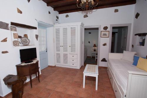 a bedroom with a bed and a tv and a desk at Patmos Chora traditional villa Genadio in Patmos