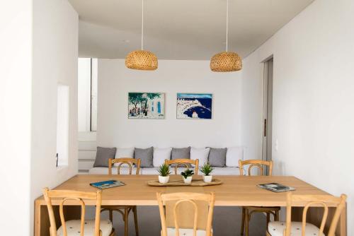 a dining room with a wooden table and chairs at Mykonos Serendipity Villas in Platis Yialos Mykonos