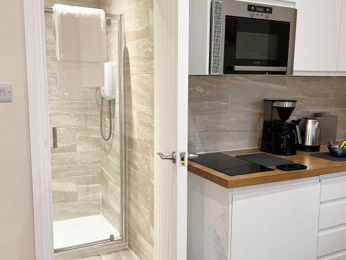 a bathroom with a shower with a glass door at Brighton Studio Flats in Brighton & Hove