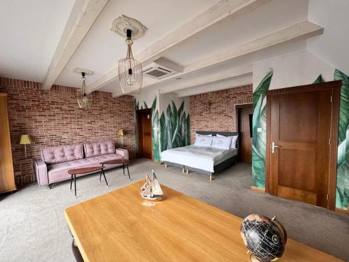 Cette chambre comprend un canapé, un lit et une table. dans l'établissement Hotel-Przystań, à Kikół