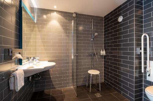 a bathroom with a sink and a shower at Holiday Inn Express Mechelen City Centre by IHG in Mechelen