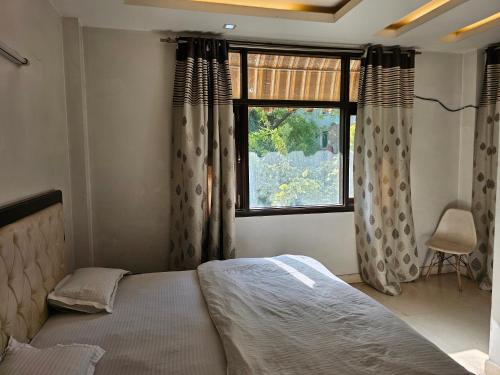 a bedroom with a bed and a window with curtains at Spacious 2bhk apartment! in New Delhi