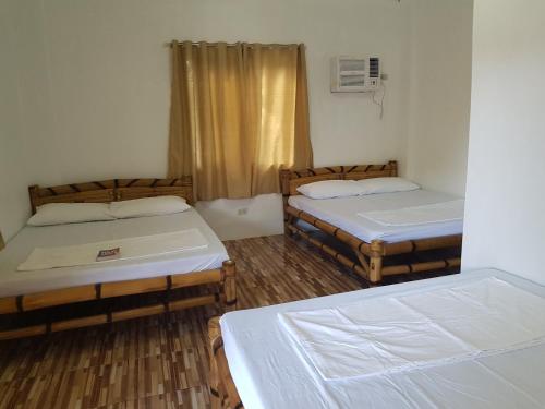 a room with two beds and a window at R&;S Restplace Resort in Matabungkay