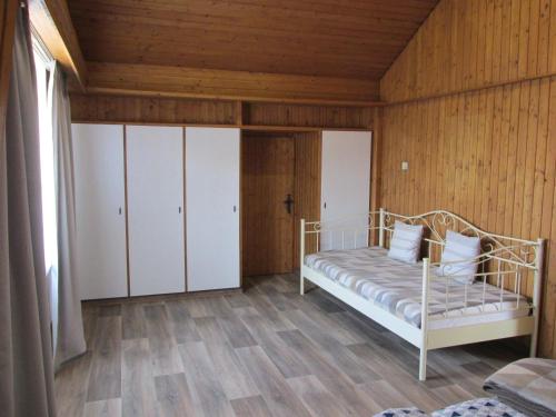 a bedroom with a bed and a wooden wall at Apartment Natali in Schnaittenbach