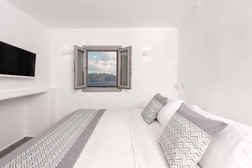 a white room with a couch and a window at Caldera Premium Villas in Oia