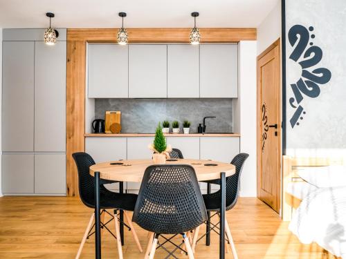 Il comprend une cuisine et une salle à manger avec une table et des chaises en bois. dans l'établissement Przy Szlaku, à Zawoja