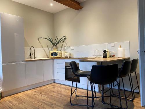 Appartement Complet Rez-de-chaussée في Sains-Richaumont: مطبخ مع طاولة وكراسي في غرفة