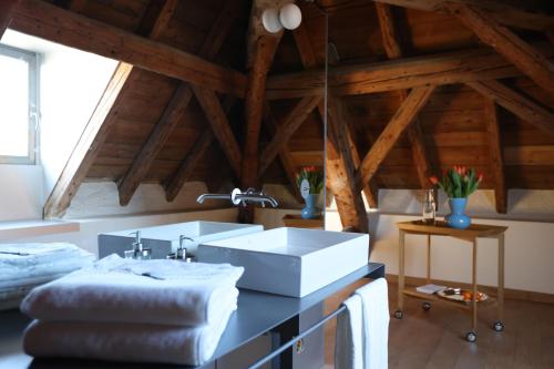 Habitación con techo de madera y baño con lavabo. en Sessius1622 en Cessy