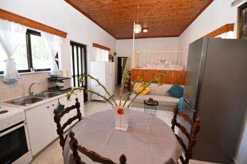 una cocina con una mesa con un jarrón. en Villa Kavalino en Kolymbia