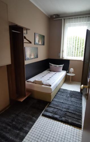 a bedroom with a bed and a window and a rug at Pension Reiter in Blomberg