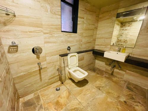 a bathroom with a toilet and a sink at Hotel Lalit inn in Lonavala