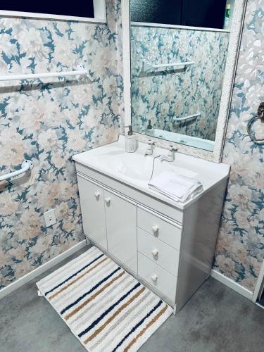 a bathroom with a sink and a mirror at River Cottage in Blenheim