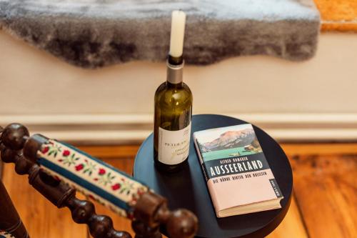 a bottle of wine and a candle on a table at Podenhaus in Bad Aussee