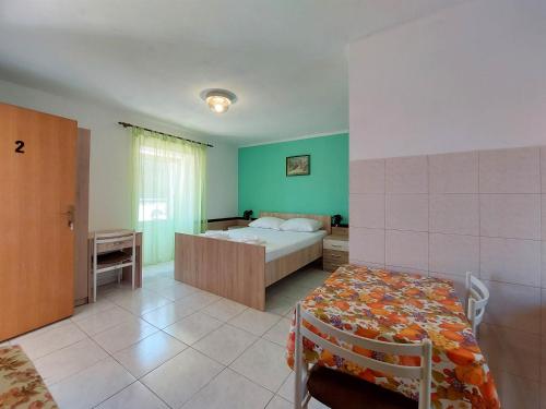 een slaapkamer met een bed en een tafel. bij Apartments Ivan in Čižići