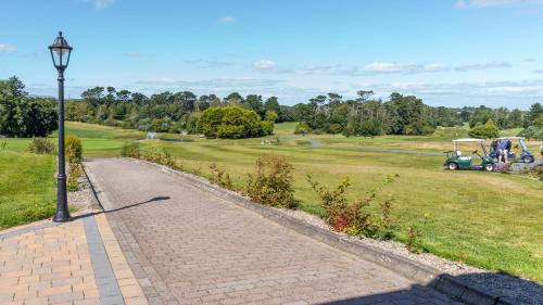 a street light next to a brick path in a park at Tramore Beach Room 5 in Waterford