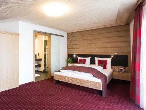 a bedroom with a large bed with red pillows at Hotel und Gästehaus Kreuz in Gammertingen