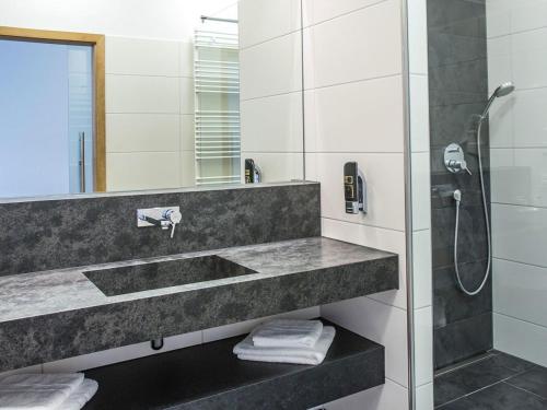 a bathroom with a sink and a shower at Hotel und Gästehaus Kreuz in Gammertingen