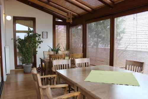 uma sala de jantar com uma grande mesa de madeira e cadeiras em Penzion Úsmev em Arnutovce