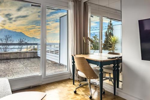 een kamer met een bureau en een raam met uitzicht bij Beautiful Studio Lake View and Castle in Veytaux
