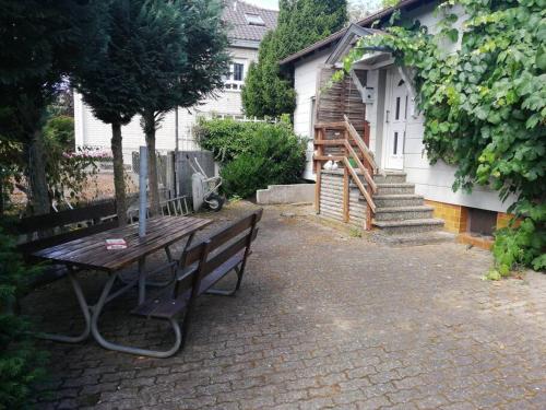 a wooden table and bench in front of a house at Einliegerwohnung, Waigolshausen in Waigolshausen