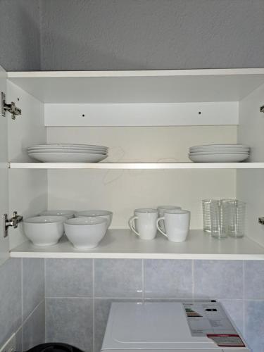 a shelf with bowls and cups and plates on it at Horizon View Chalets in Graskop
