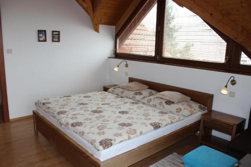 a bedroom with a bed in a room with a window at Penzion Úsmev in Arnutovce
