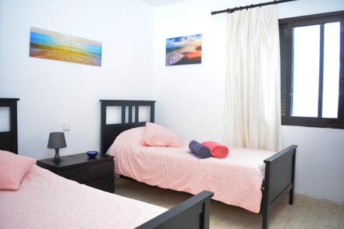 1 dormitorio con 2 camas y ventana en Habitacion doble con baño entrada privada para huéspedes en San Bartolomé