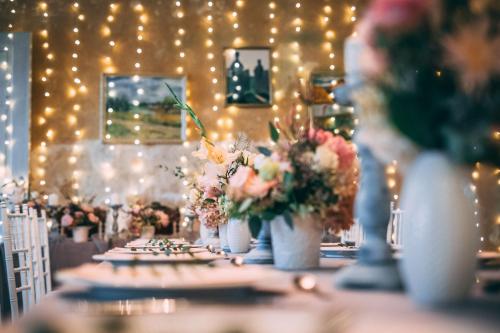 a table with vases of flowers on it with lights at Blankenfeldes muiža in Tērvete