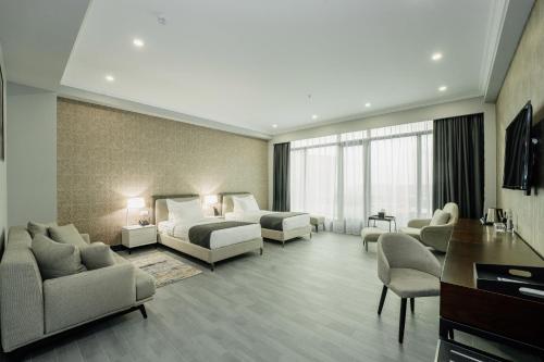 a hotel room with two beds and a living room at Hills Resort Hotel in Yerevan