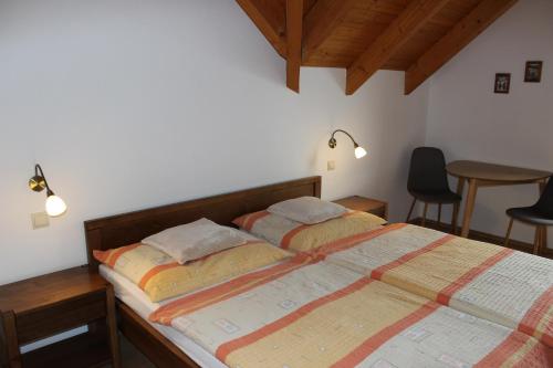 a bedroom with two beds and a table and chairs at Penzion Úsmev in Arnutovce