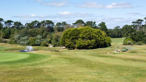 een uitzicht op een golfbaan met een fontein bij Brownstown Head Room 4 in Waterford