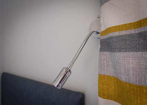 um candeeiro pendurado numa parede ao lado de uma cama em Brownstown Head Room 4 em Waterford