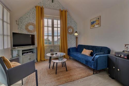 a living room with a blue couch and a tv at Les Mots Bleus in Dinard