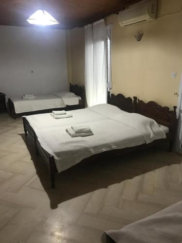 a bedroom with two beds and a window at Pansion Angela in Skiathos Town