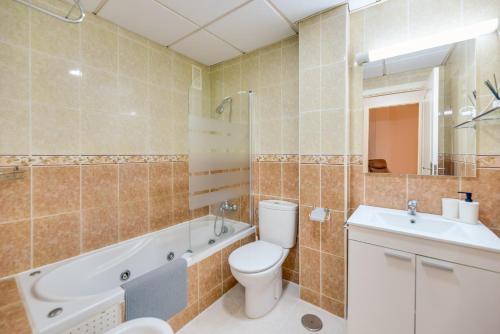 een badkamer met een toilet, een bad en een wastafel bij VB Golf Beach 2BDR Apt in Benalmádena