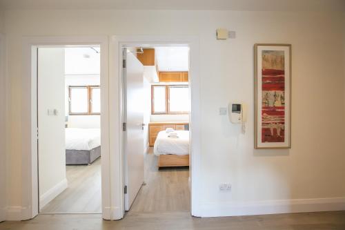 biały pokój z sypialnią i łóżkiem w obiekcie IFSC Townhouse Apartments w Dublinie