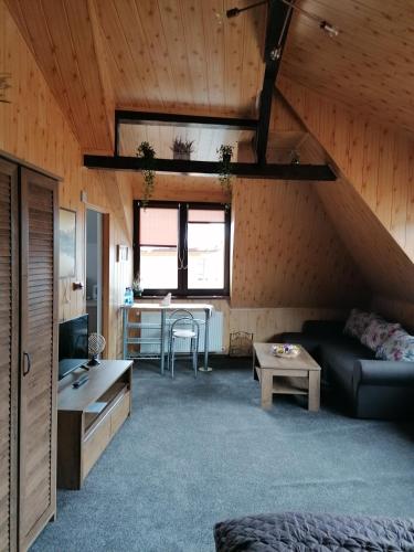 a living room with a couch and a table at Cozy attic studio in Braşov