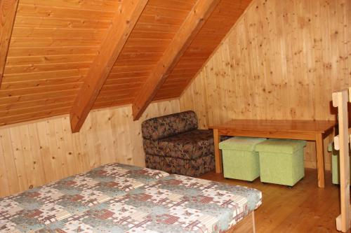 a room with a bed and a desk and a chair at Penzion Úsmev in Arnutovce