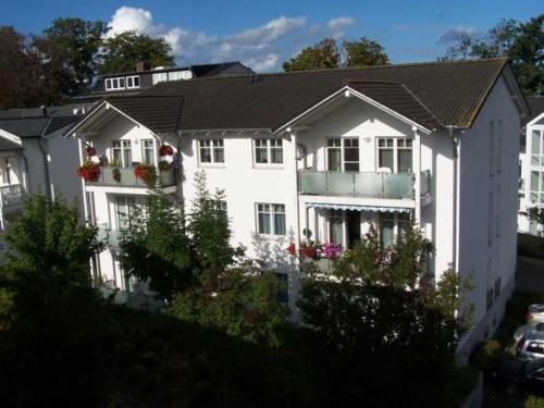 a white house with flowers on the windows at Appartement Granitz - Ferienwohnung Thoenissen in Göhren